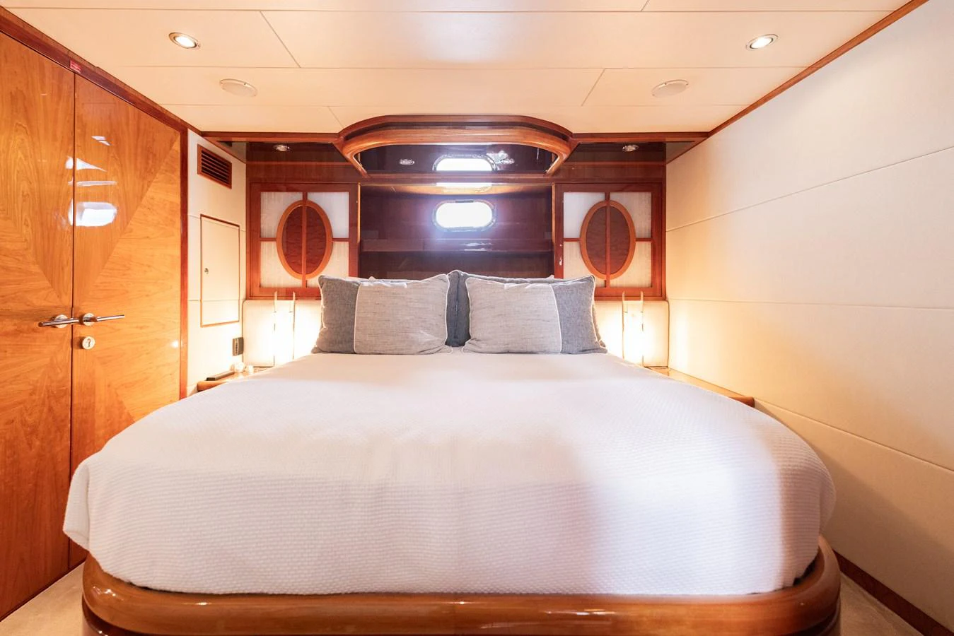 The stateroom features a luxurious bed with elegant wood finishes and soft lighting. aboard SASSY Yacht for Sale