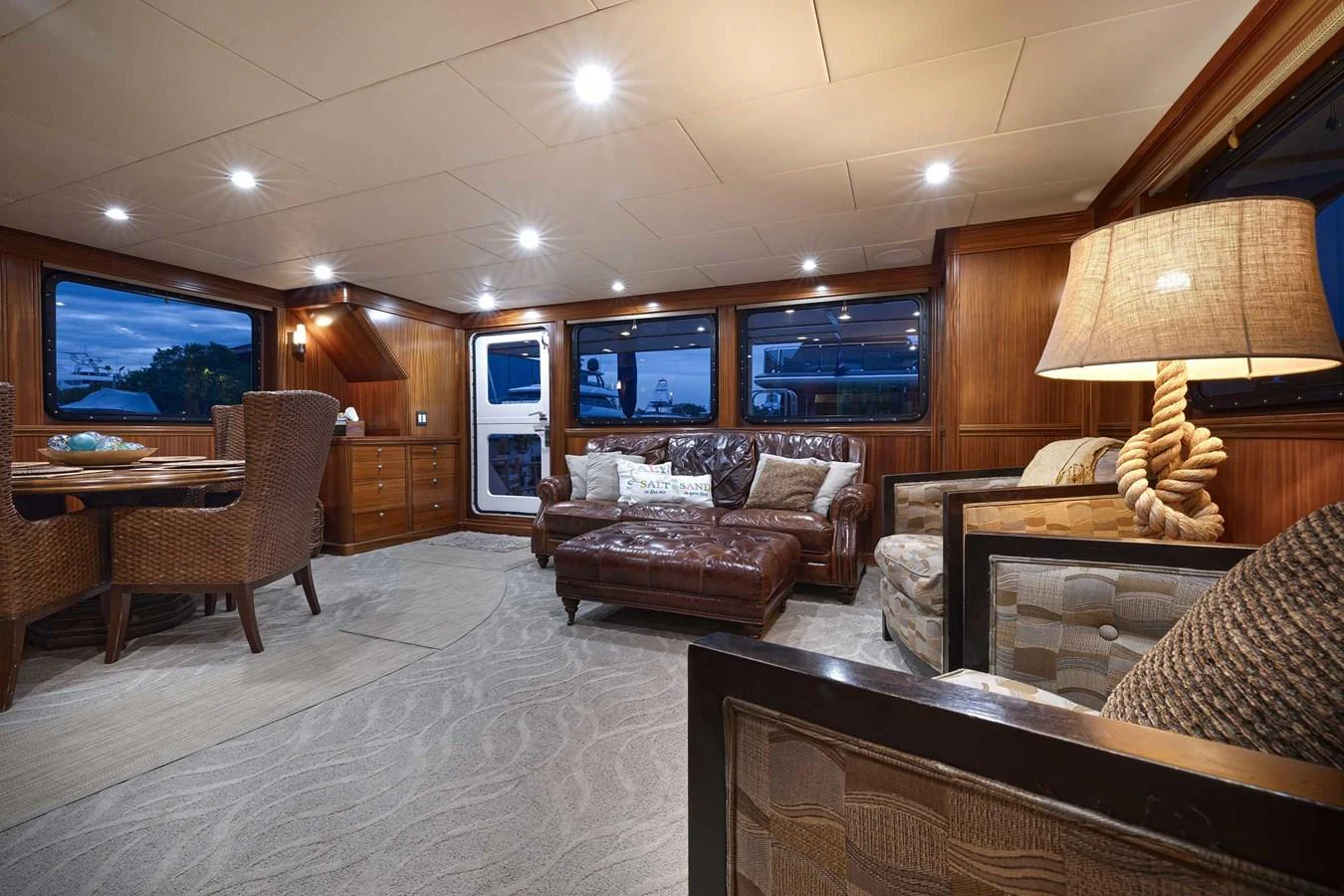 The yacht's salon features luxurious seating with a warm, inviting ambiance. aboard HEAVEN'S GATE Yacht for Sale