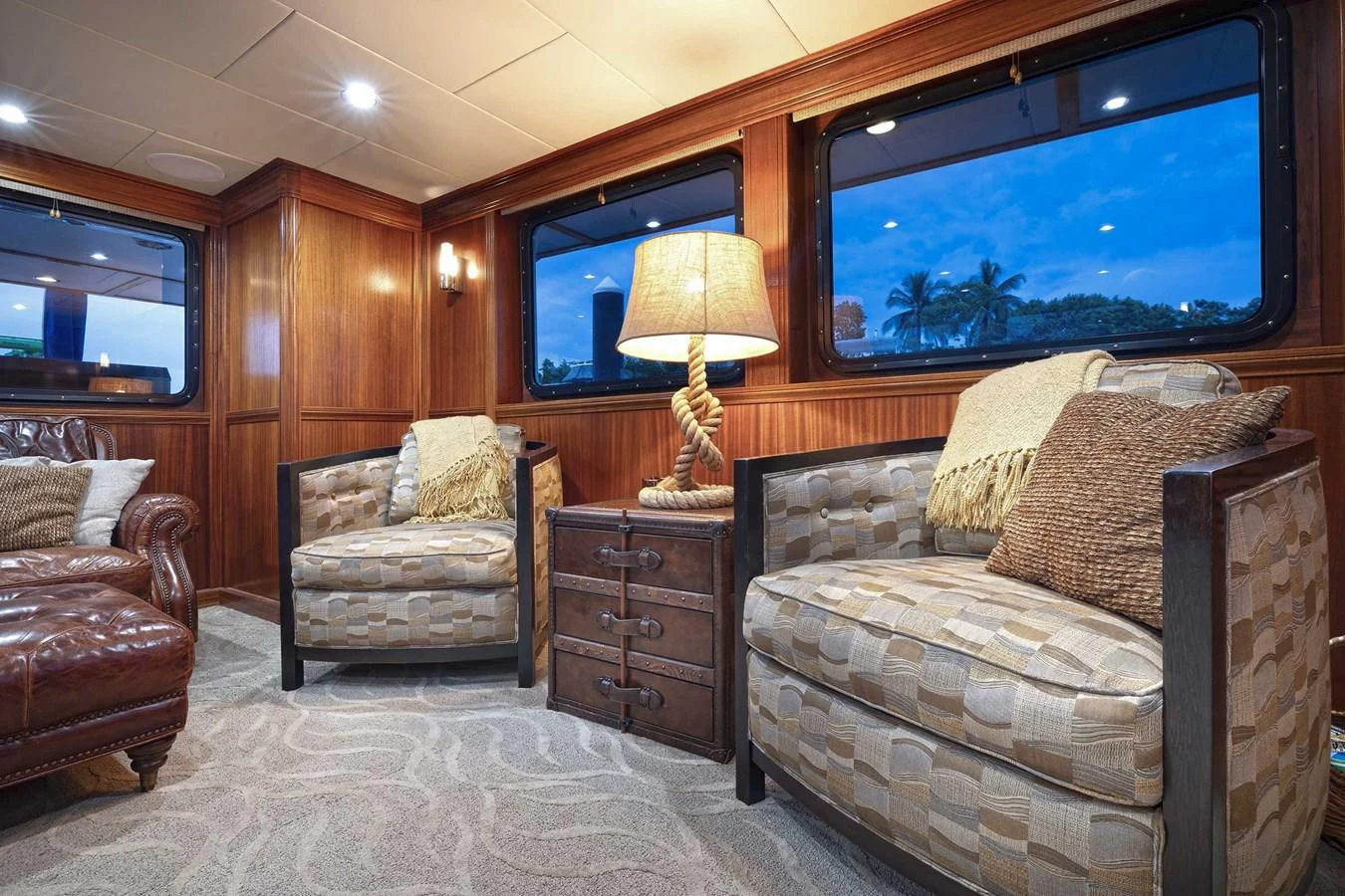 The cozy interior lounge features plush seating and warm wood paneling, creating an inviting atmosphere. aboard HEAVEN'S GATE Yacht for Sale