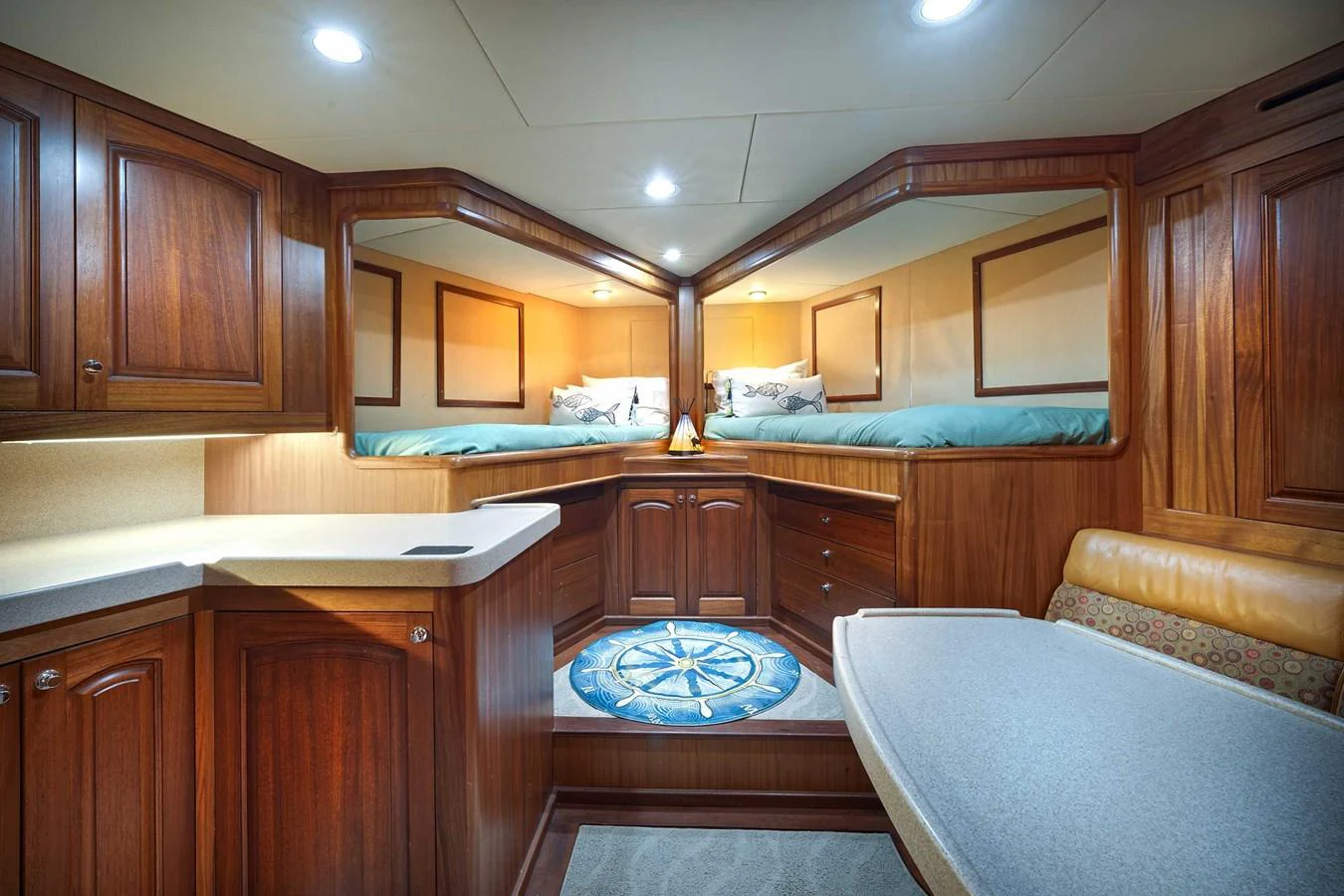 The yacht's cabin features rich wooden cabinetry, a cozy bed, and a stylish seating area. aboard HEAVEN'S GATE Yacht for Sale