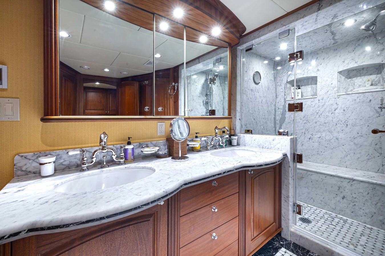 The yacht's bathroom features a luxurious marble countertop and a spacious glass-enclosed shower. aboard HEAVEN'S GATE Yacht for Sale