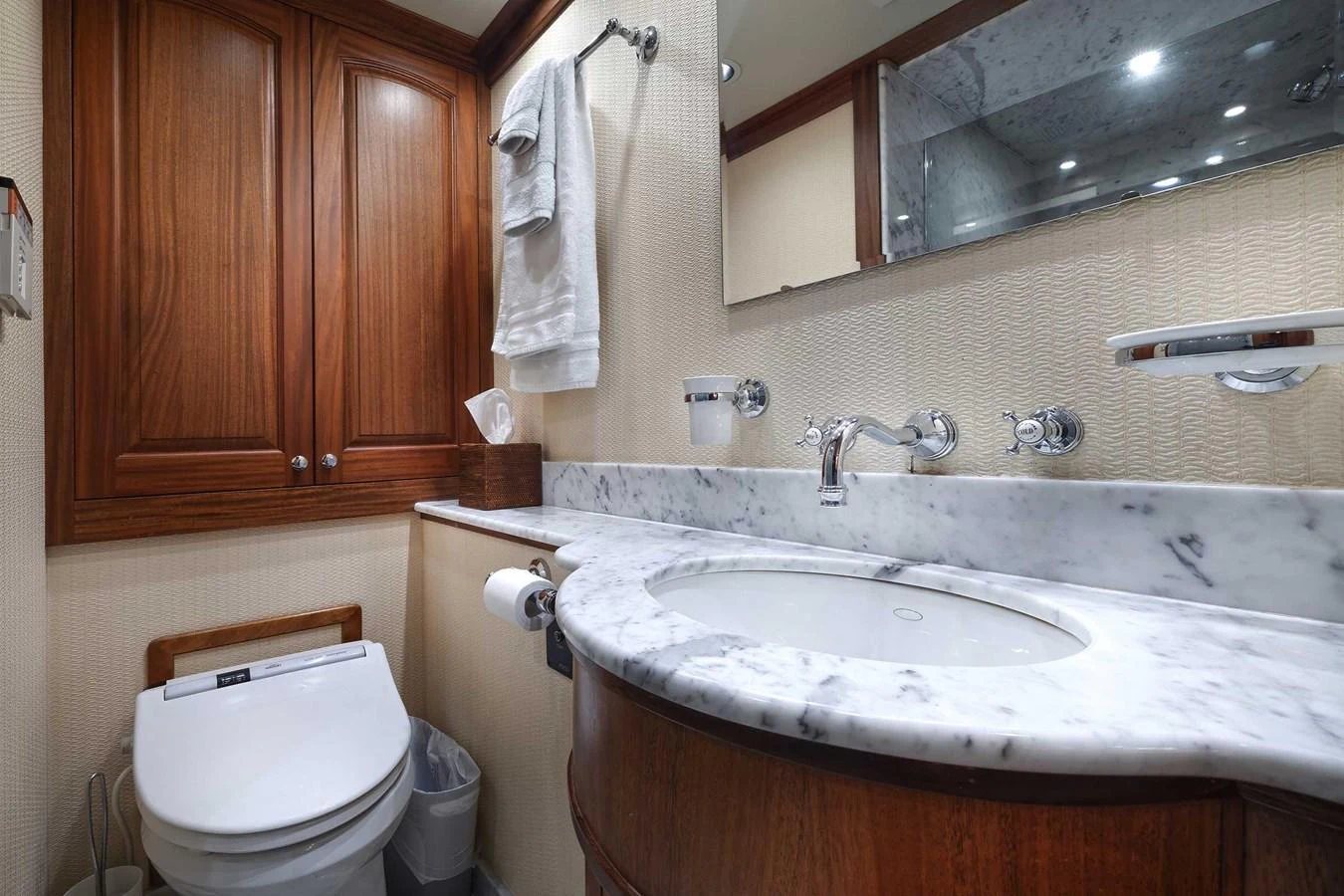 The yacht's head features elegant wood cabinetry and a marble countertop, creating a luxurious and functional space. aboard HEAVEN'S GATE Yacht for Sale
