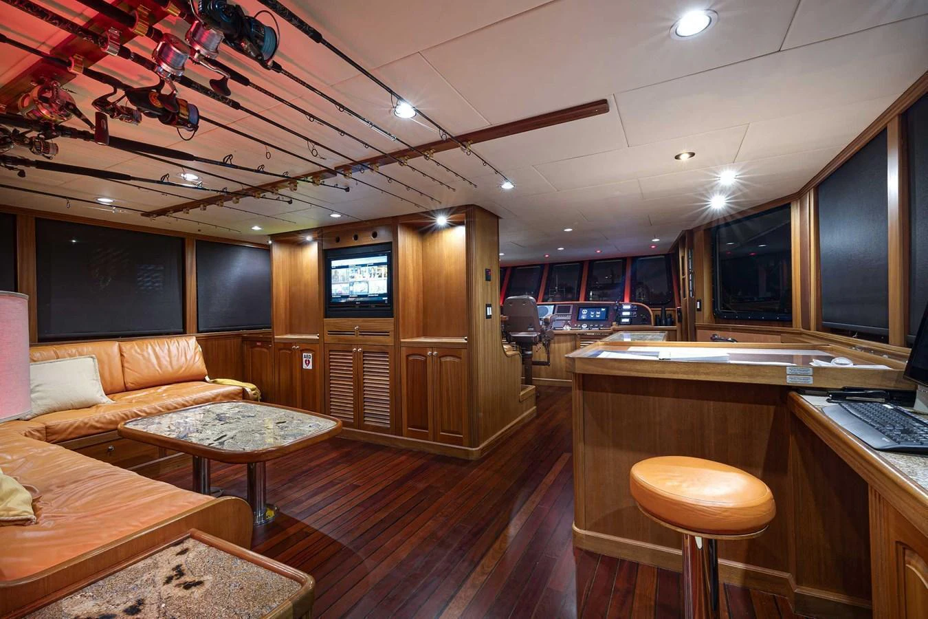 The yacht's salon features a cozy seating area with a view of the helm station, complemented by warm wooden finishes and modern amenities. aboard HEAVEN'S GATE Yacht for Sale