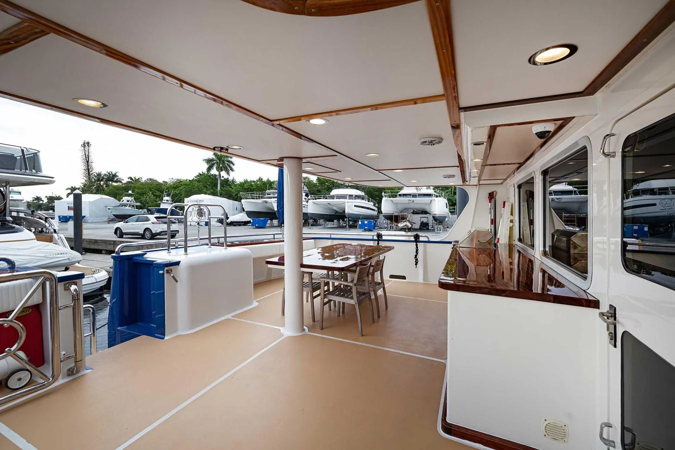 The aft deck features a spacious dining area with a polished wooden table and comfortable seating, perfect for alfresco dining. aboard HEAVEN'S GATE Yacht for Sale