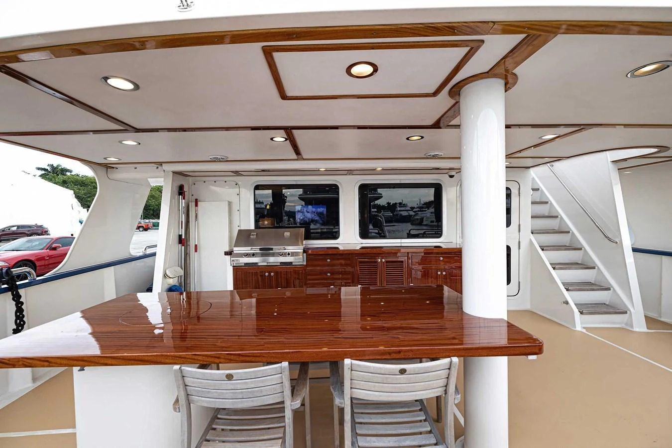 The aft deck features a polished wooden table and comfortable seating, perfect for outdoor dining and relaxation. aboard HEAVEN'S GATE Yacht for Sale