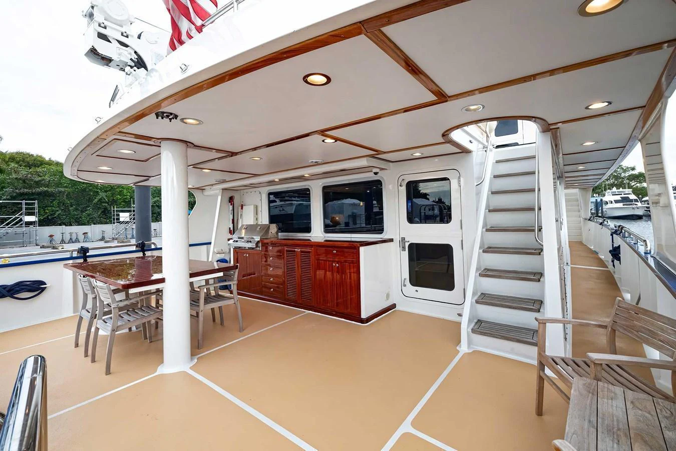 The aft deck features a spacious outdoor dining area with a staircase leading to the upper deck. aboard HEAVEN'S GATE Yacht for Sale
