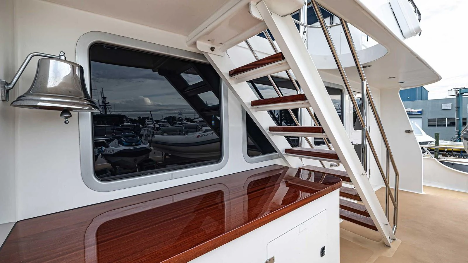 The aft deck features a polished wooden counter and a staircase leading to the upper deck. aboard HEAVEN'S GATE Yacht for Sale