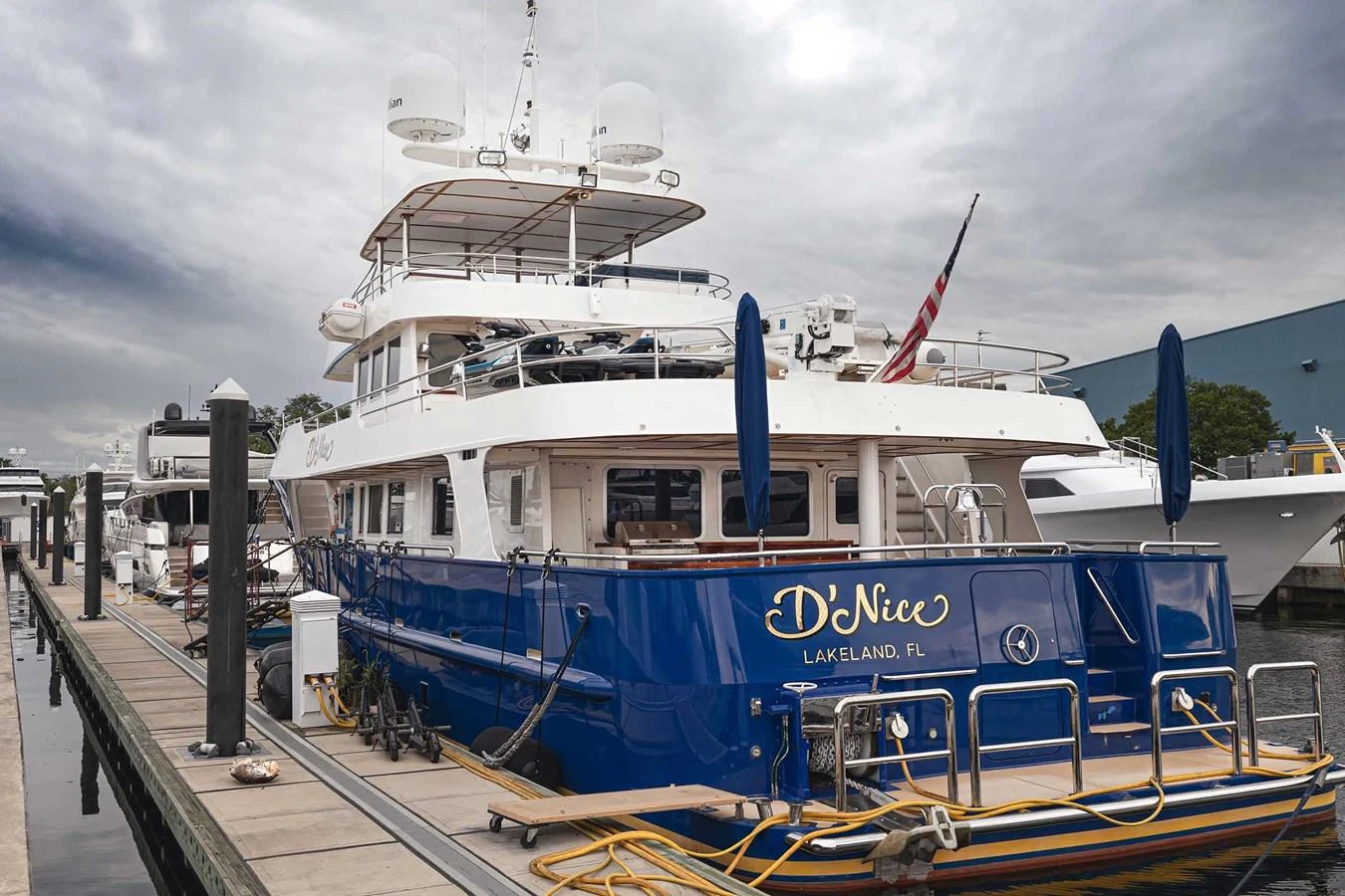 A luxurious yacht is docked at a marina, showcasing its elegant design and spacious deck. aboard HEAVEN'S GATE Yacht for Sale