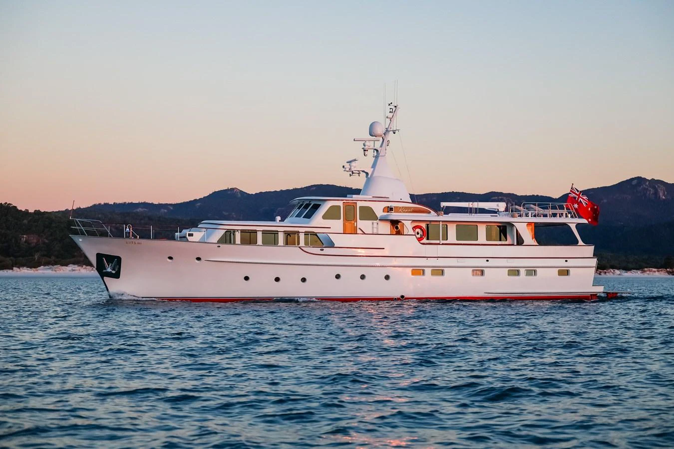 A classic yacht cruising on calm waters during sunset. aboard VICTORIA Yacht for Sale