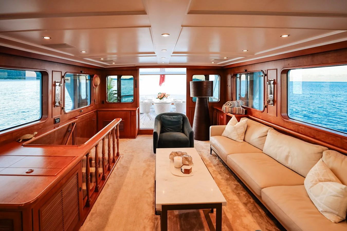 The yacht's salon features elegant wood paneling, plush seating, and expansive windows offering stunning ocean views. aboard VICTORIA Yacht for Sale