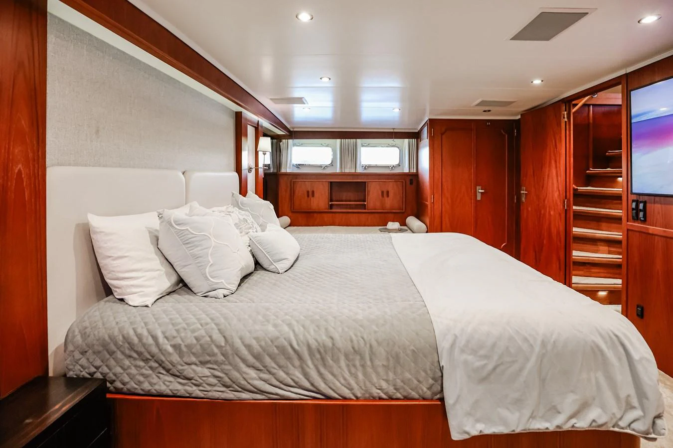 The master stateroom features a spacious bed with elegant bedding and warm wood finishes. aboard VICTORIA Yacht for Sale