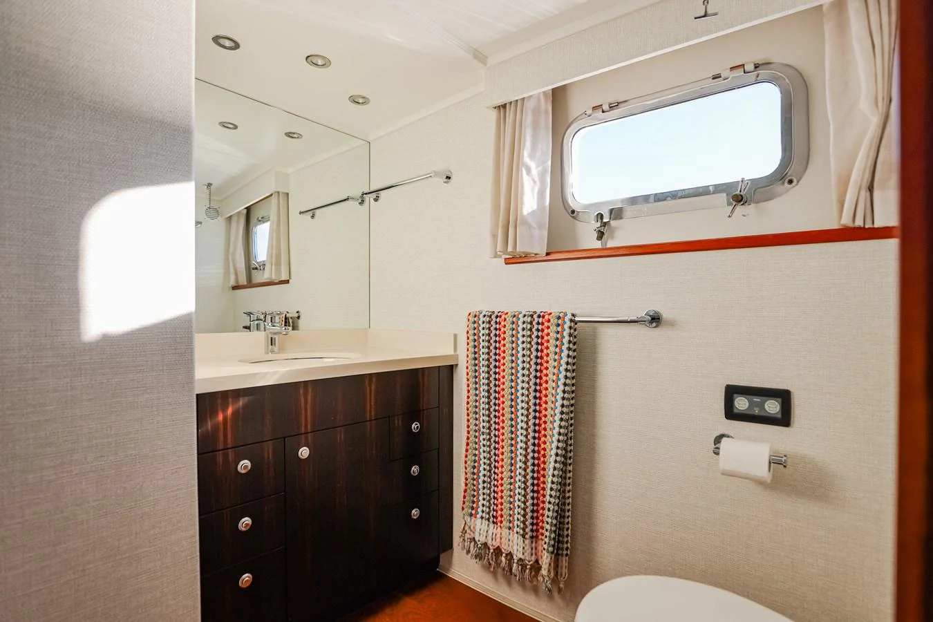 The yacht's bathroom features a sleek vanity, a porthole window, and modern fixtures. aboard VICTORIA Yacht for Sale