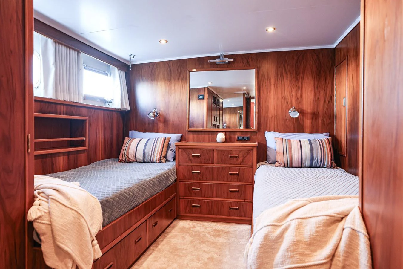 This cozy twin stateroom features warm wood paneling and comfortable bedding, creating a welcoming retreat. aboard VICTORIA Yacht for Sale