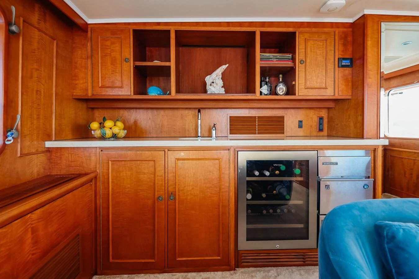 The yacht's galley features rich wooden cabinetry, a wine cooler, and ample counter space for a luxurious culinary experience. aboard VICTORIA Yacht for Sale