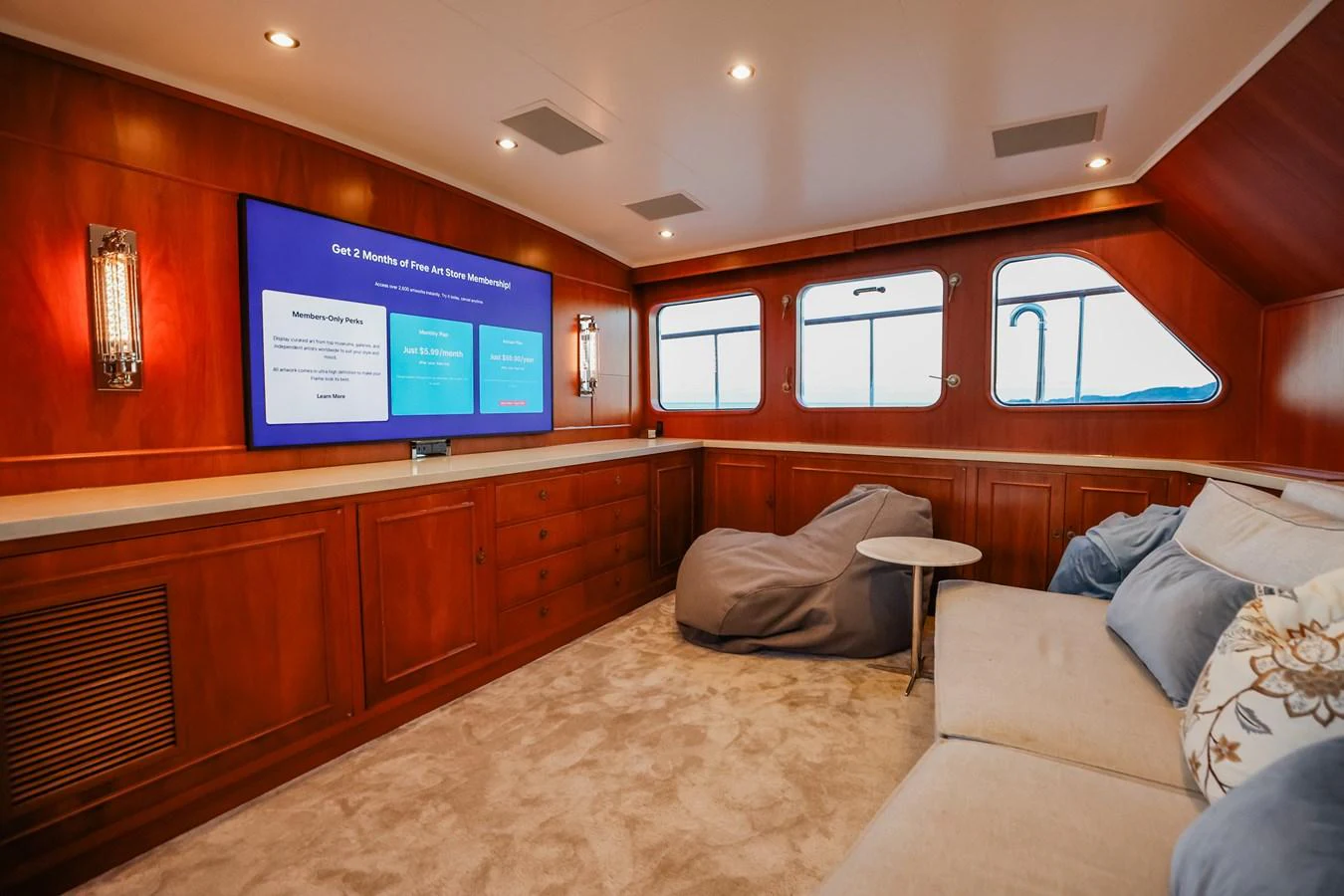 A cozy lounge area with a large TV, comfortable seating, and elegant wood paneling. aboard VICTORIA Yacht for Sale