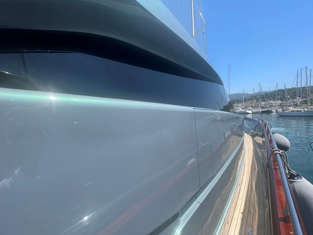 A sleek and modern yacht hull reflecting the marina's serene surroundings. aboard UNICA Yacht for Sale