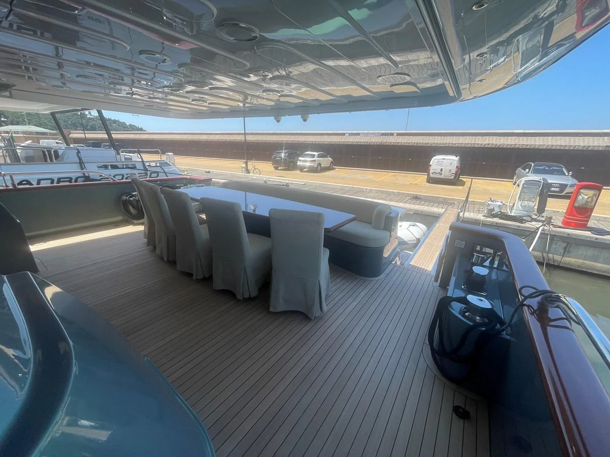 The aft deck features an elegant dining area with a large table and comfortable chairs, perfect for alfresco meals. aboard UNICA Yacht for Sale