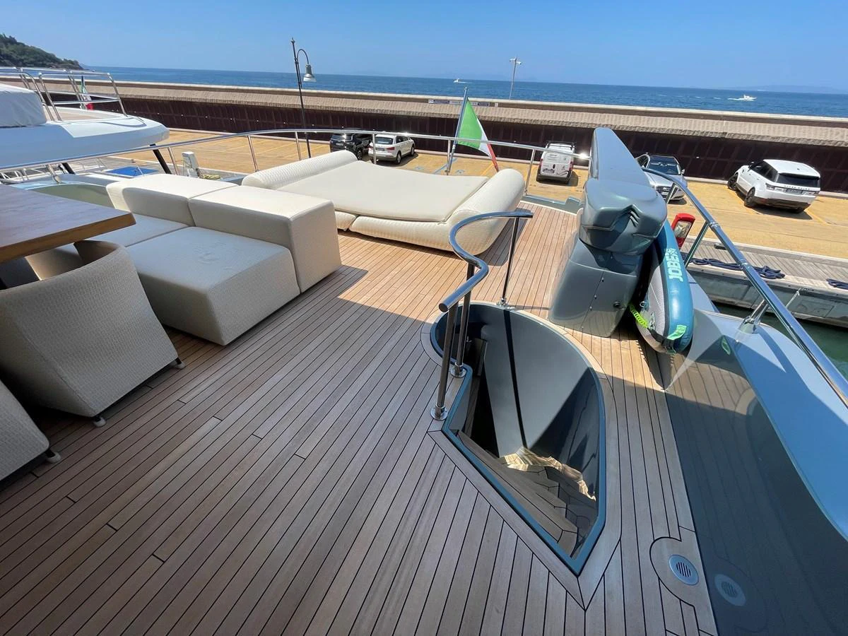 The aft deck features a spacious lounging area with comfortable seating and a large sunbed, perfect for relaxation. aboard UNICA Yacht for Sale