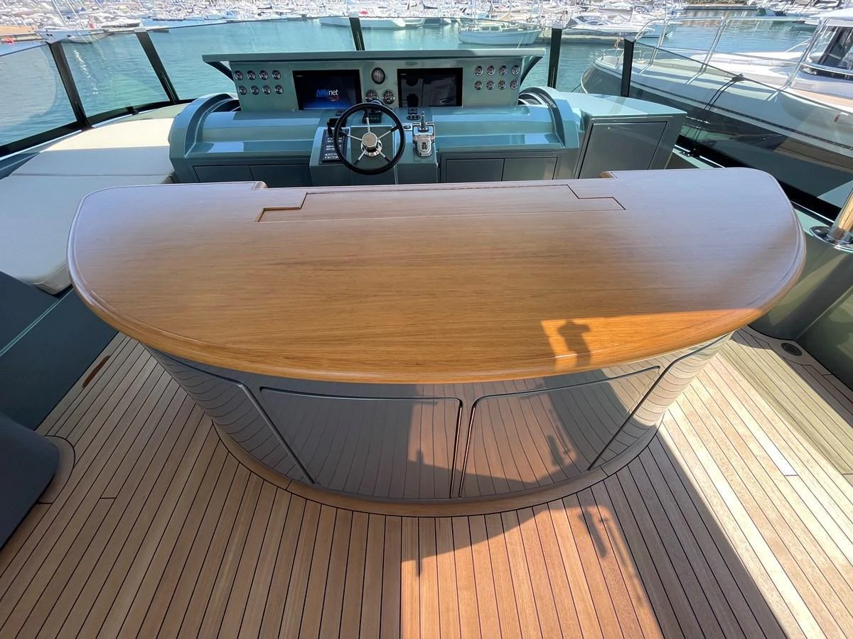 The helm station features a sleek wooden console and modern navigation equipment. aboard UNICA Yacht for Sale