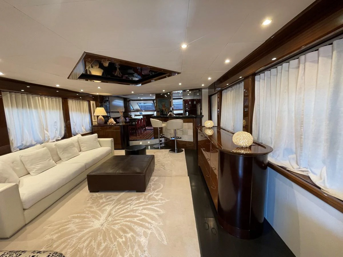 The yacht's salon features elegant furnishings and ample natural light through large windows. aboard UNICA Yacht for Sale