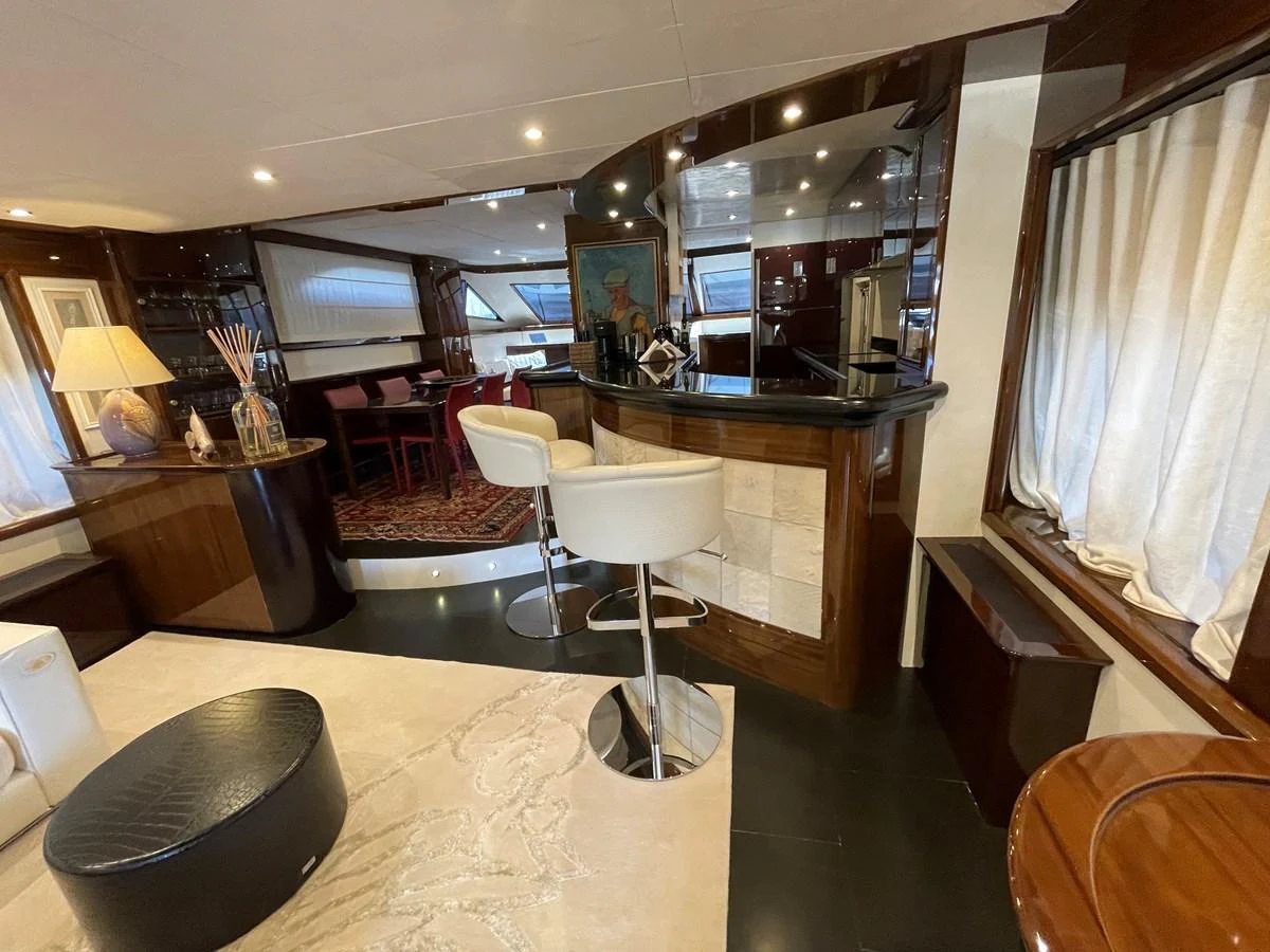 The yacht's salon features a stylish bar area with modern seating and elegant decor. aboard UNICA Yacht for Sale