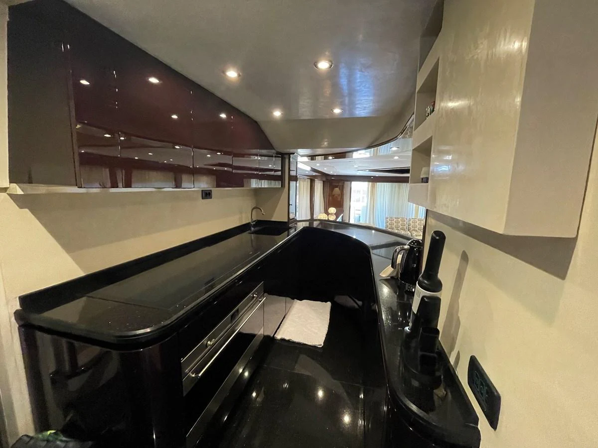 The galley features sleek black countertops and modern cabinetry, creating a sophisticated cooking space. aboard UNICA Yacht for Sale