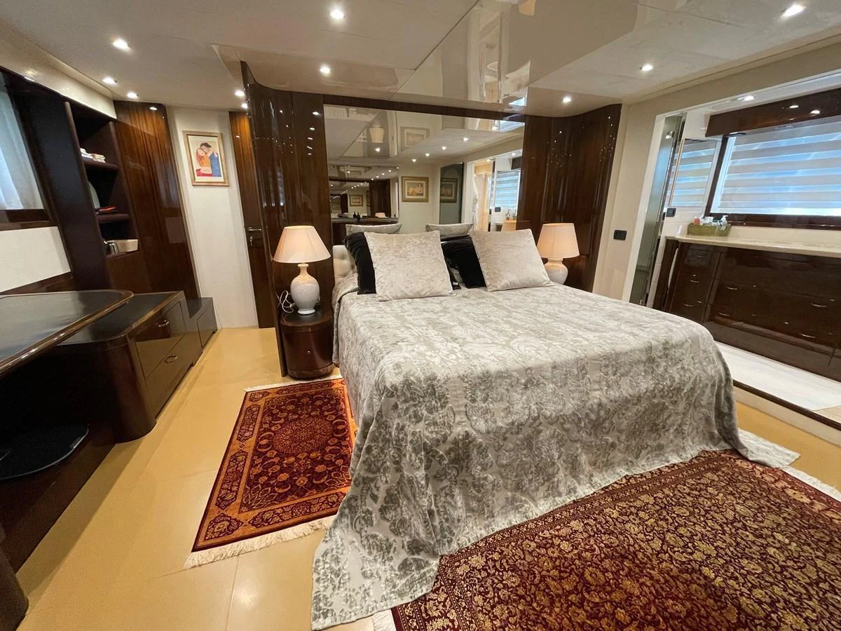 The master stateroom features a luxurious bed with elegant decor and ample natural light. aboard UNICA Yacht for Sale