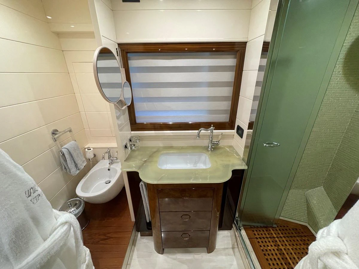A well-appointed bathroom featuring a glass-enclosed shower, vanity, and bidet. aboard UNICA Yacht for Sale
