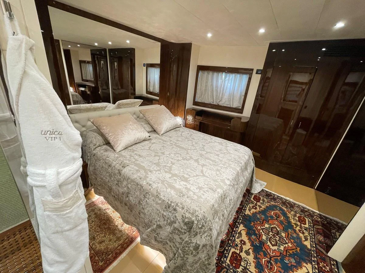 The stateroom features a comfortable bed with elegant bedding and a cozy atmosphere. aboard UNICA Yacht for Sale