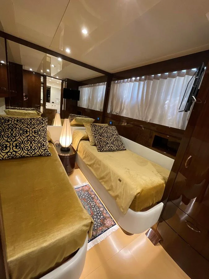 The guest cabin features twin beds with luxurious bedding and elegant decor. aboard UNICA Yacht for Sale