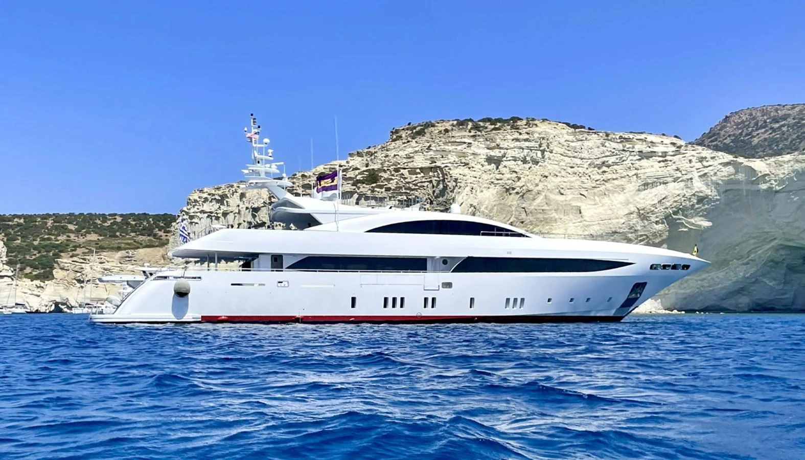A sleek and modern yacht cruising along a picturesque coastline with clear blue waters. aboard BARENTS SEA Yacht for Sale