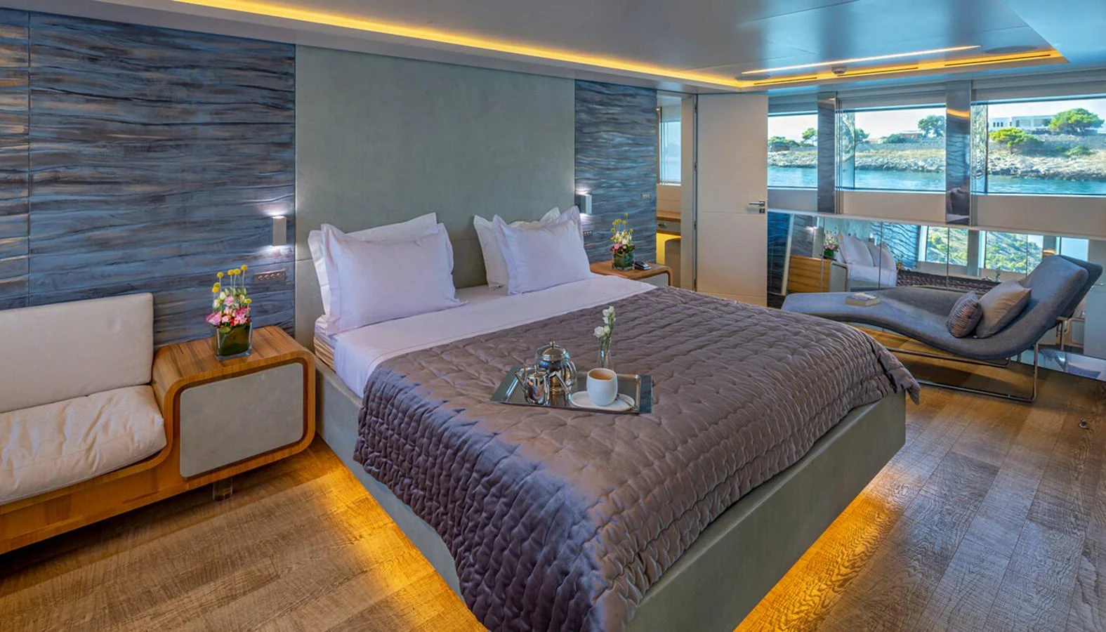 The master stateroom features a luxurious bed, modern decor, and large windows offering stunning views. aboard BARENTS SEA Yacht for Sale