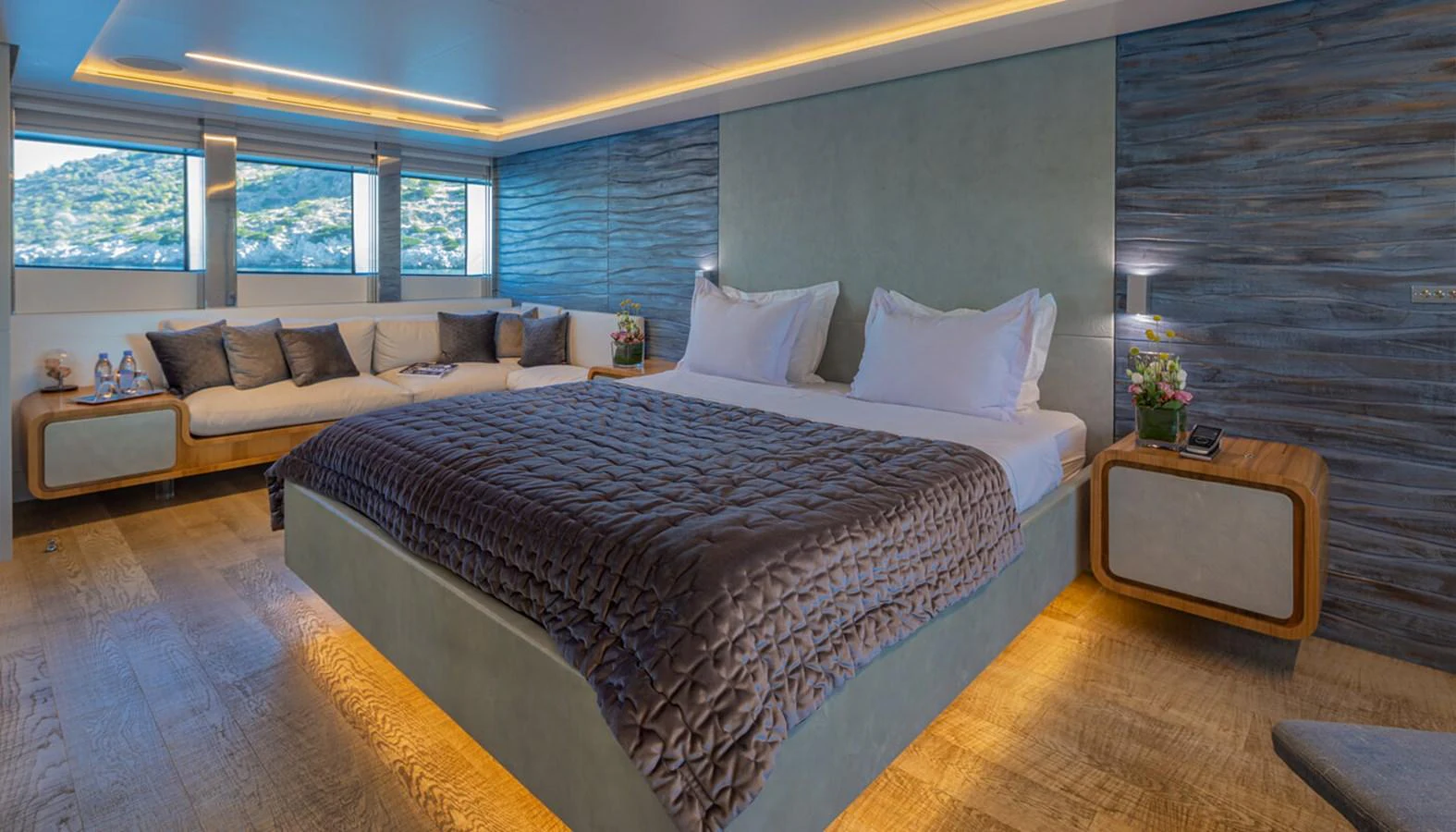 The master stateroom features a luxurious bed, ambient lighting, and a comfortable seating area with scenic views. aboard BARENTS SEA Yacht for Sale
