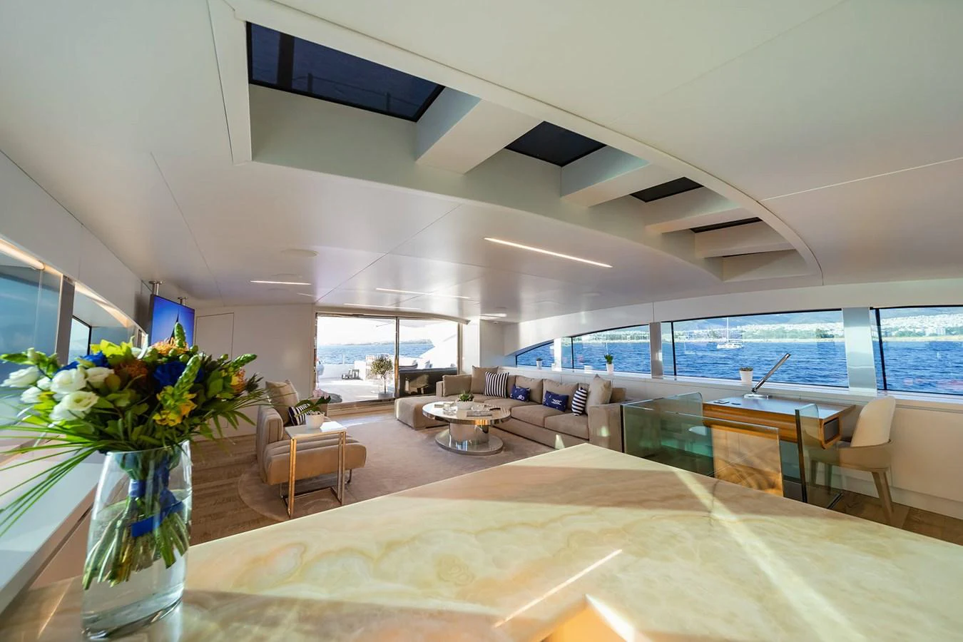 The spacious salon features modern furnishings and panoramic windows offering stunning sea views. aboard BARENTS SEA Yacht for Sale
