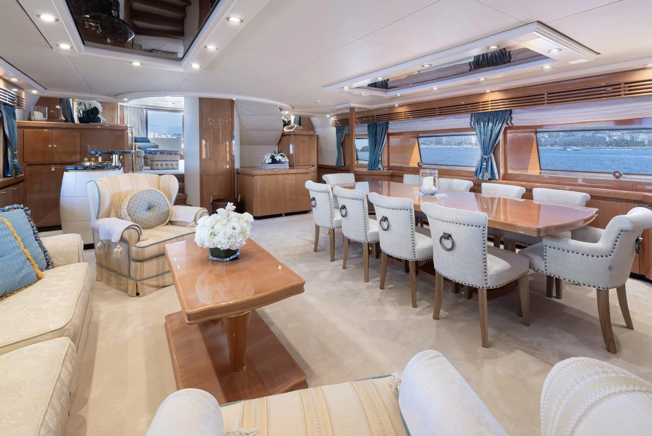 The yacht's salon features elegant furnishings and expansive windows offering stunning sea views. aboard M.J. TAKNM Yacht for Sale