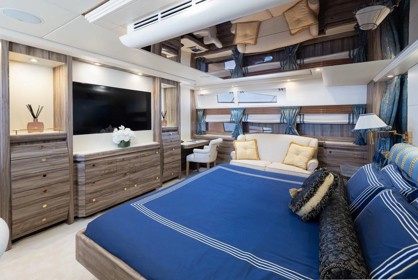 The master stateroom features a luxurious bed with elegant bedding, ample storage, and a cozy seating area. aboard M.J. TAKNM Yacht for Sale