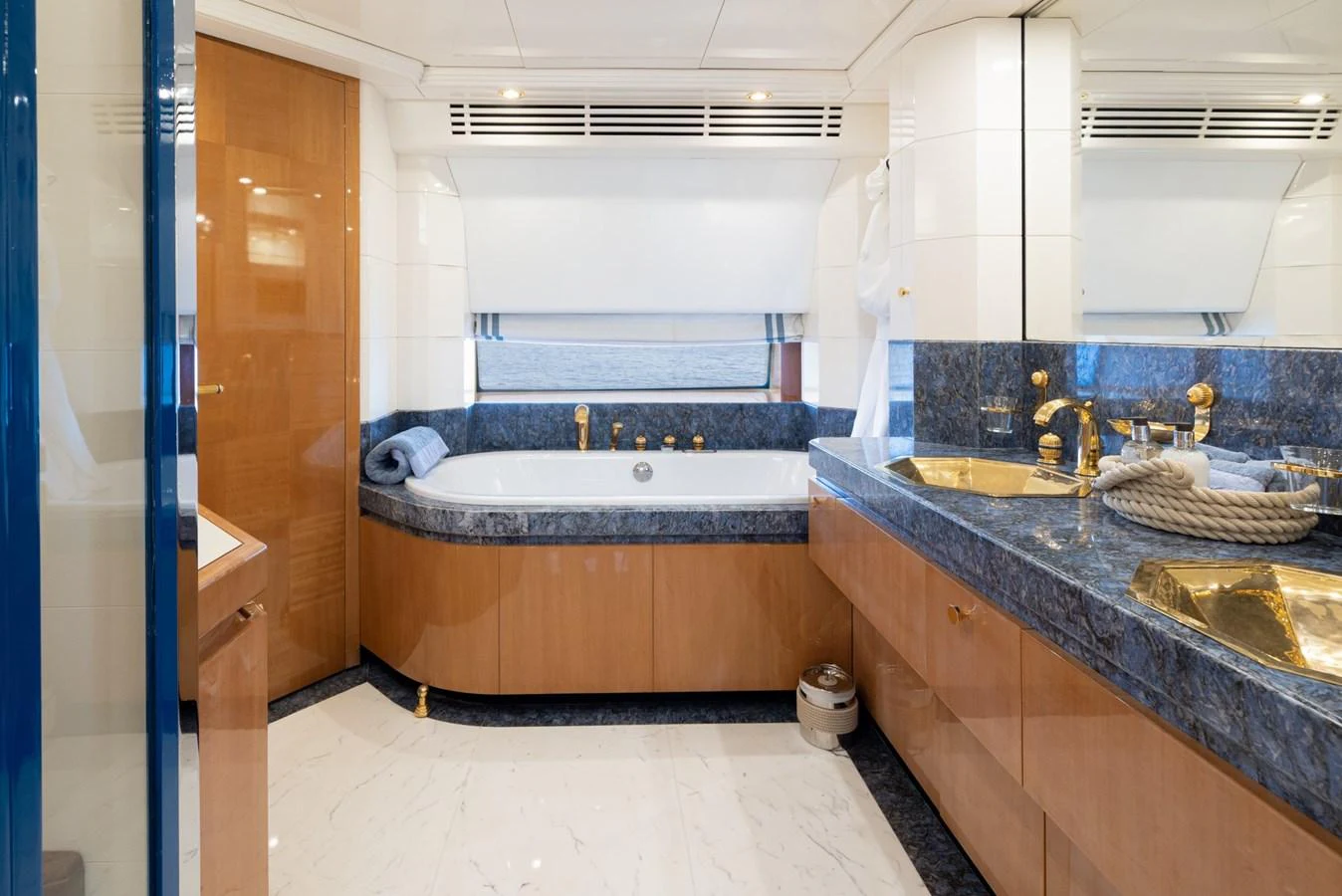 The bathroom features luxurious fixtures and a spacious layout with a large window offering a serene view. aboard M.J. TAKNM Yacht for Sale