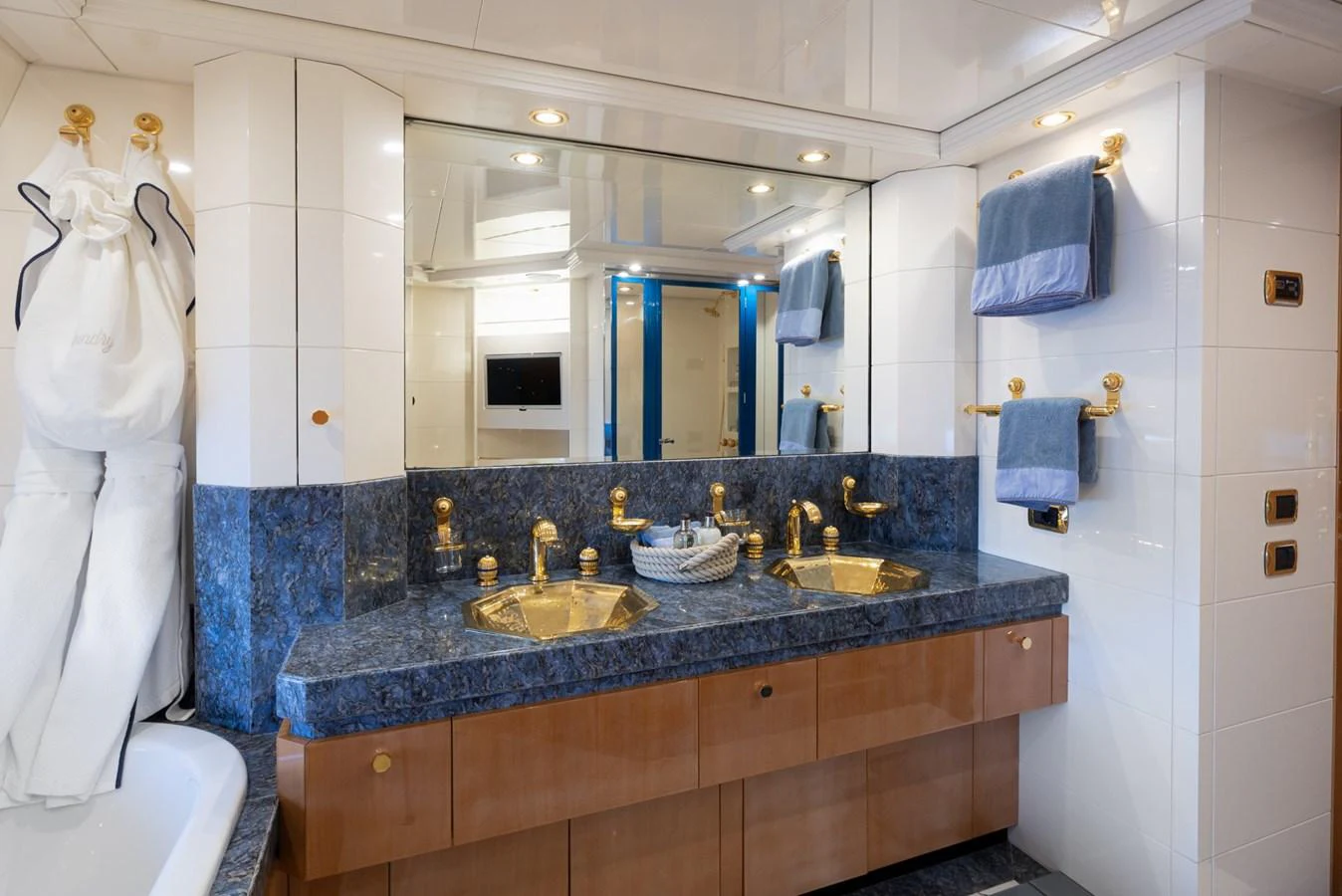 The yacht's bathroom features elegant blue marble countertops and gold fixtures, creating a luxurious atmosphere. aboard M.J. TAKNM Yacht for Sale