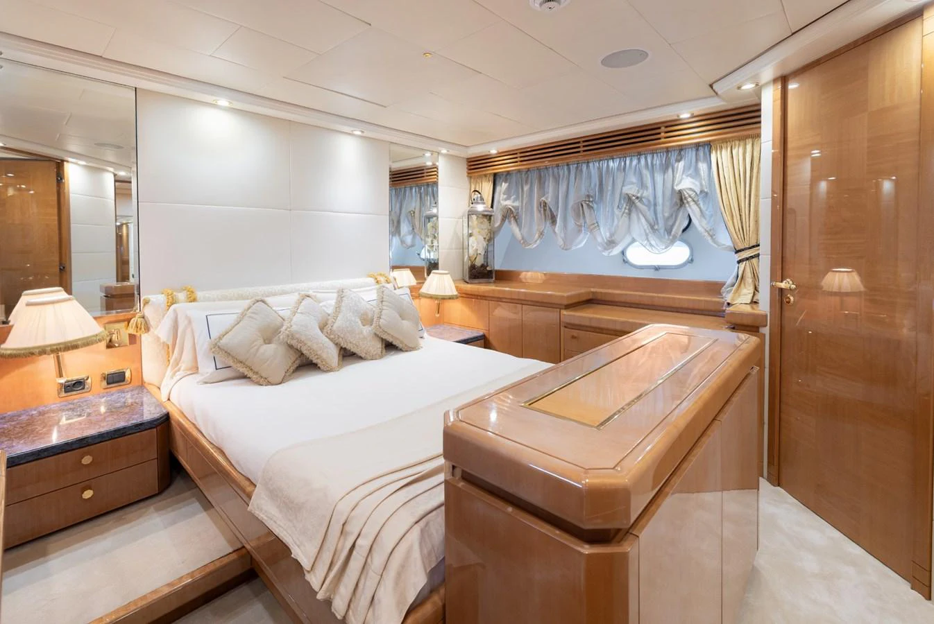 The master stateroom exudes luxury with its plush bedding, elegant wood finishes, and ample natural light. aboard M.J. TAKNM Yacht for Sale