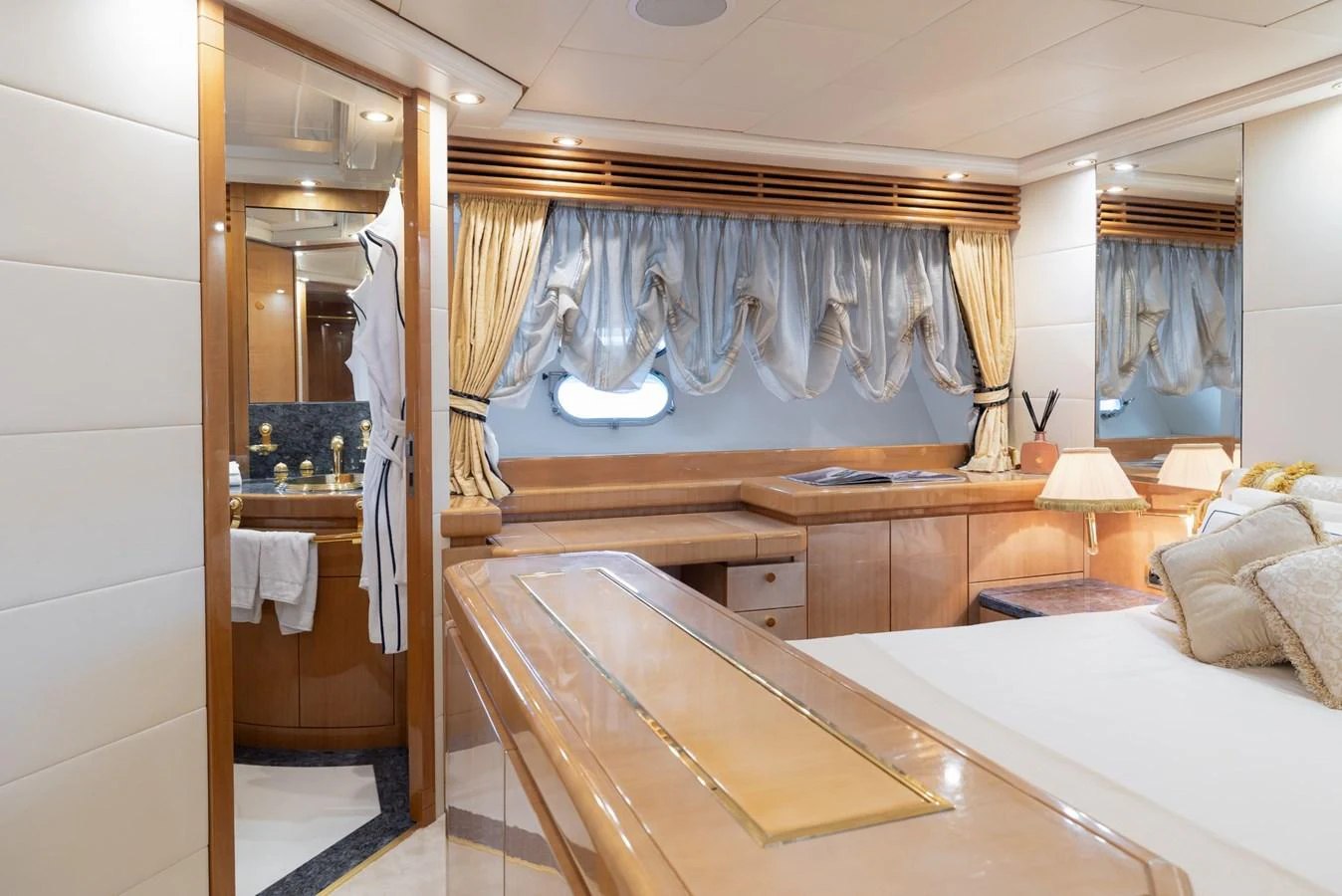 The stateroom features elegant wood finishes, luxurious bedding, and ample natural light through large windows. aboard M.J. TAKNM Yacht for Sale