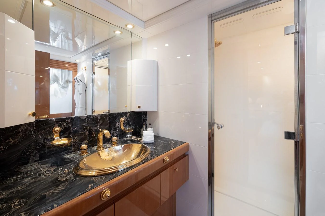 The bathroom features a luxurious design with a marble countertop and gold fixtures. aboard M.J. TAKNM Yacht for Sale