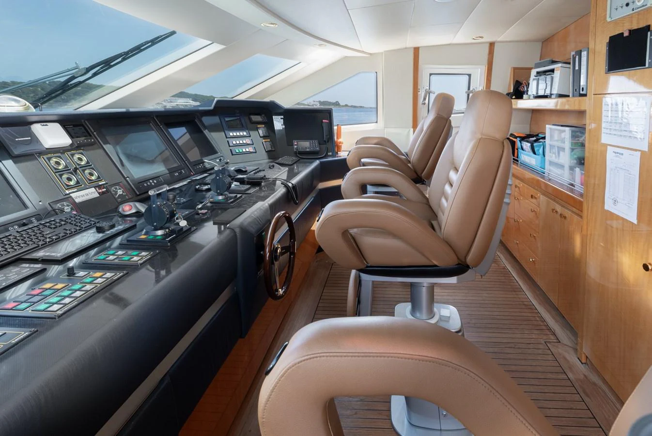 The helm station features state-of-the-art navigation equipment and luxurious leather seating. aboard M.J. TAKNM Yacht for Sale