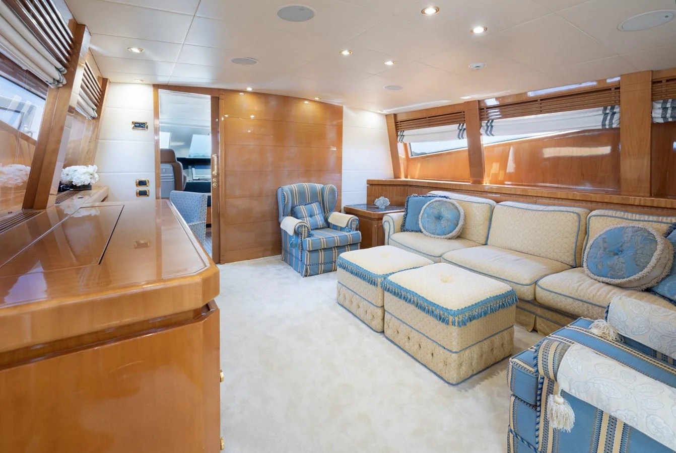 The salon features plush seating and elegant wood finishes, creating a cozy and refined atmosphere. aboard M.J. TAKNM Yacht for Sale