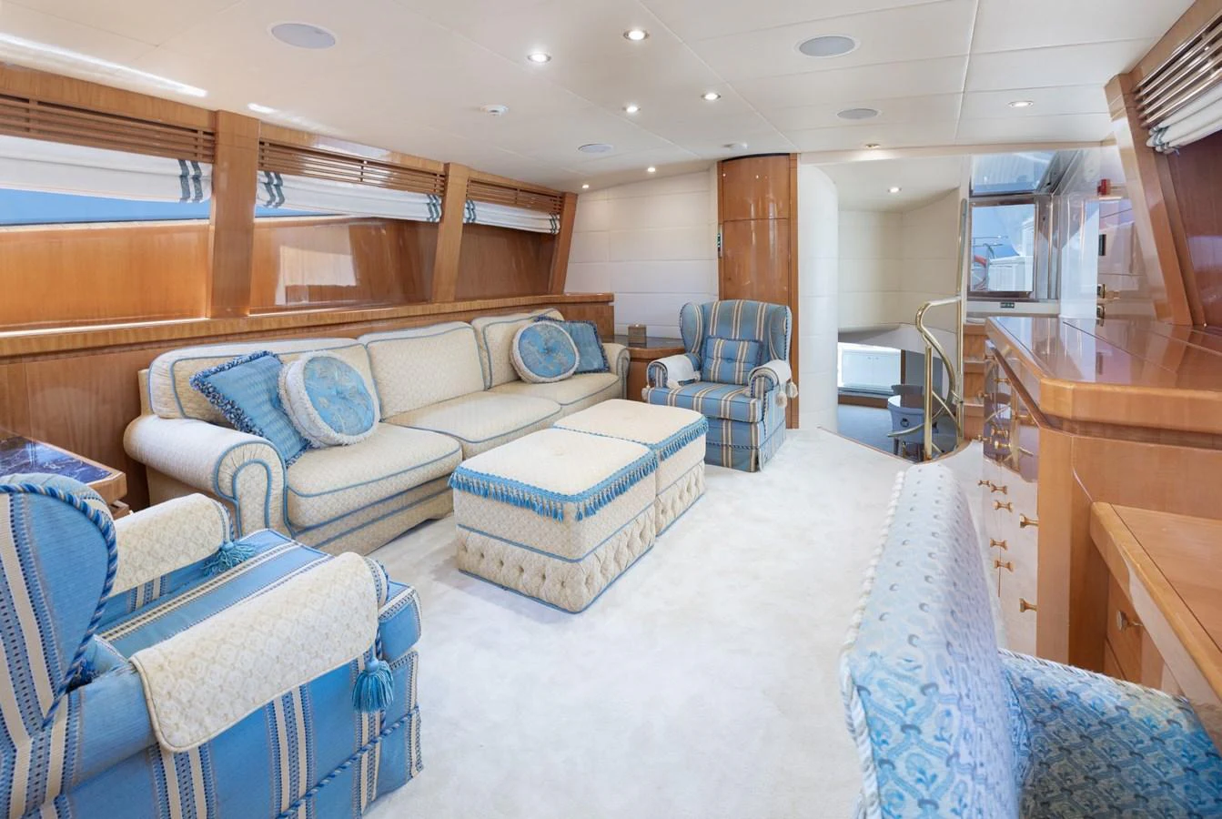 The salon features plush seating and elegant decor in a spacious and well-lit environment. aboard M.J. TAKNM Yacht for Sale