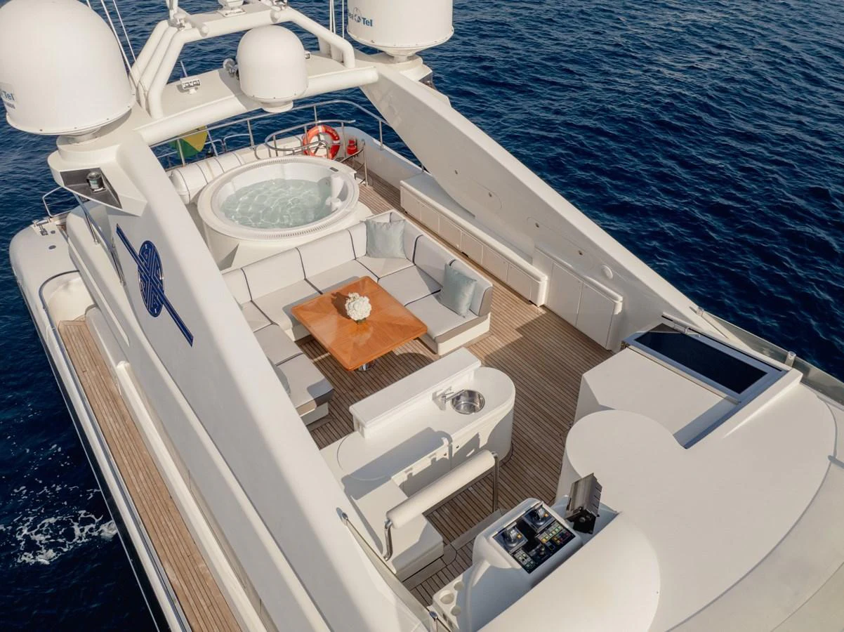 The sundeck features a luxurious jacuzzi, ample seating, and a stylish dining area with stunning ocean views. aboard M.J. TAKNM Yacht for Sale