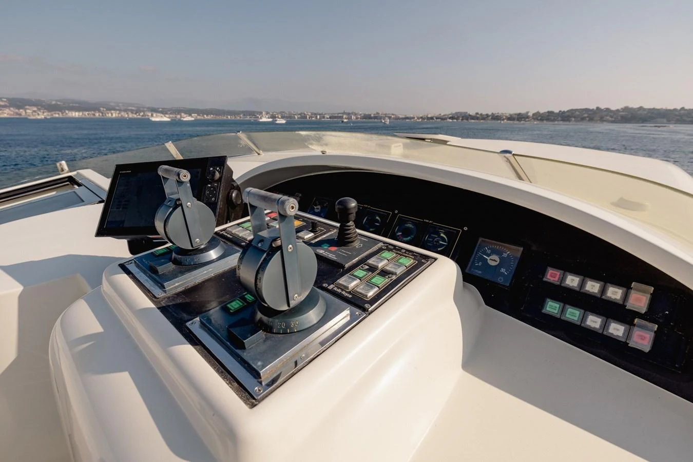 The helm station features advanced navigation controls with a scenic view of the water. aboard M.J. TAKNM Yacht for Sale
