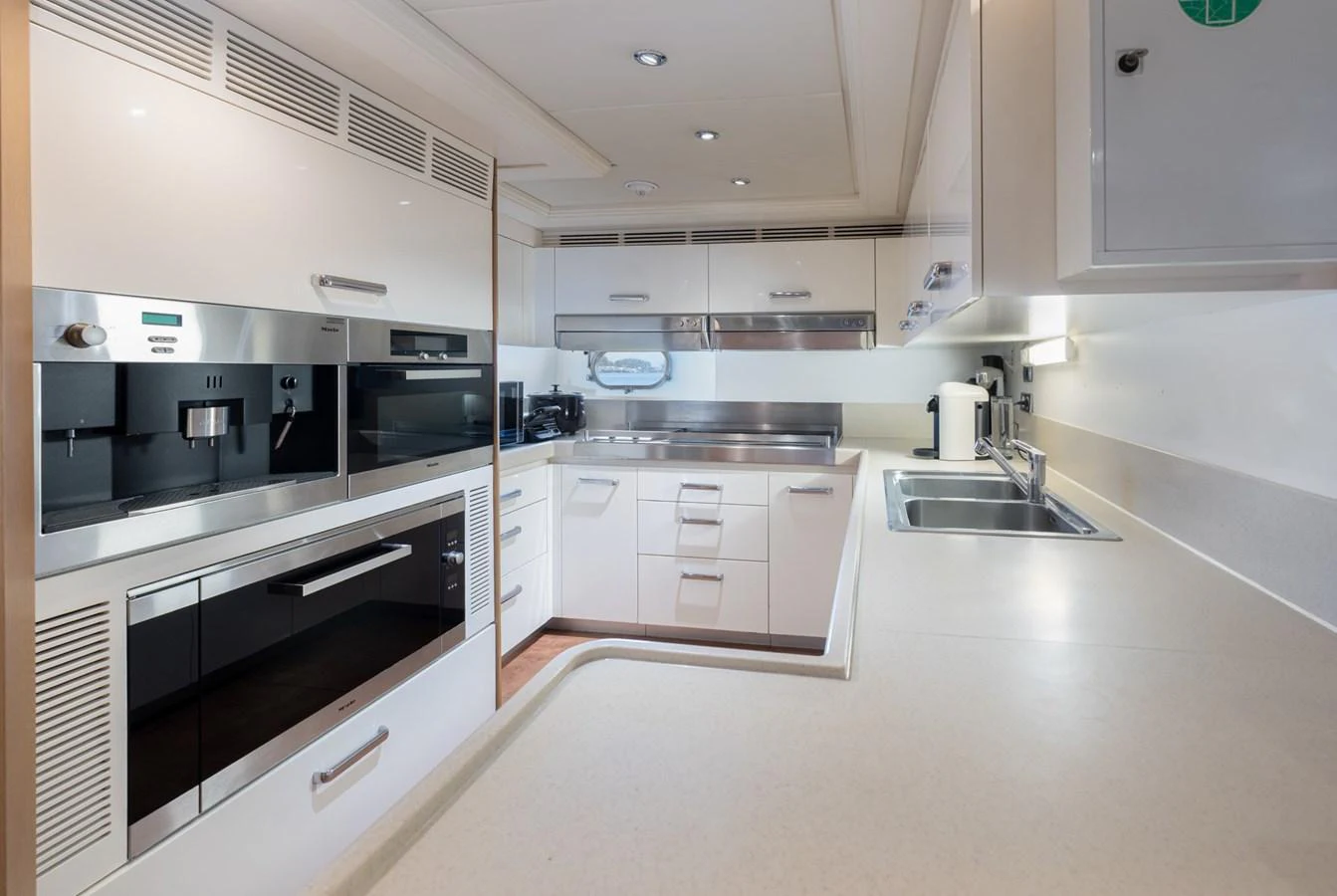 The yacht's galley features modern appliances and a sleek, functional design. aboard M.J. TAKNM Yacht for Sale