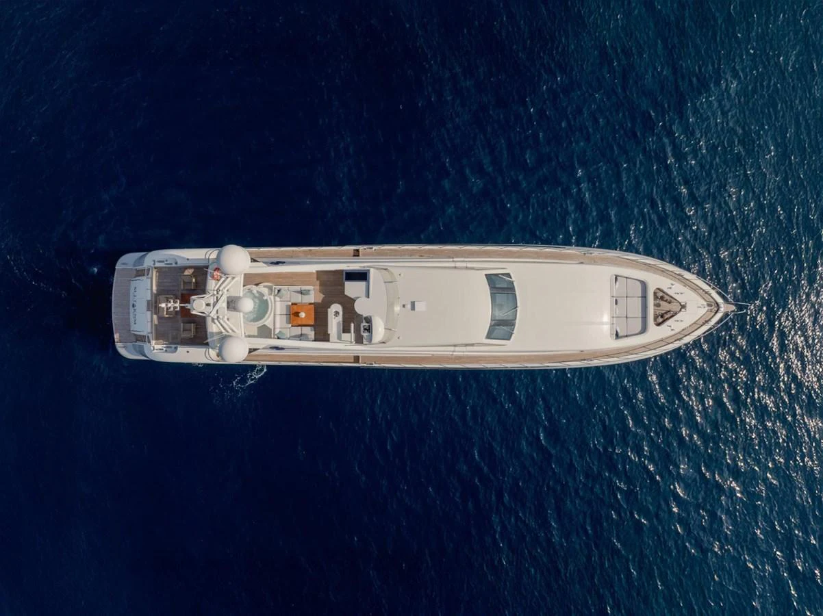 Aerial view of a sleek yacht cruising through deep blue waters. aboard M.J. TAKNM Yacht for Sale