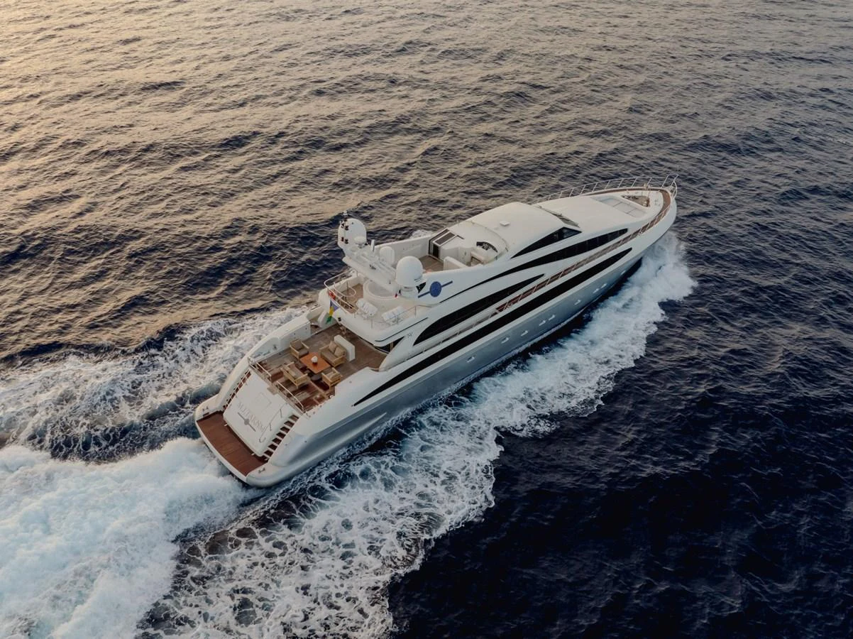 A sleek and modern yacht cruises through the open sea, showcasing its elegant design and spacious deck. aboard M.J. TAKNM Yacht for Sale