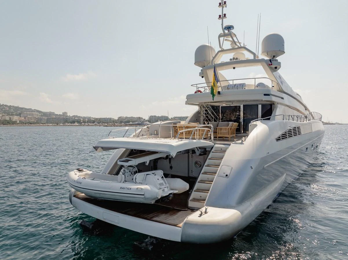 The yacht's aft deck features a spacious lounging area with a tender ready for launch. aboard M.J. TAKNM Yacht for Sale